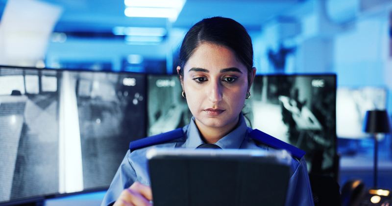 Security operative reviewing information on a tablet in a control room